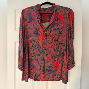 Large, flowy blouse with deep colors of red, purple, and green.